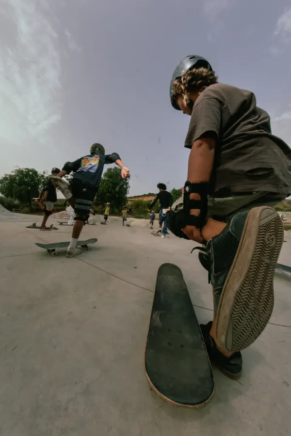 Low-angle shot of a skater stretching next to his board