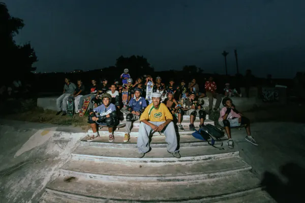 Casa Skate Club community sitting together on the skatepark steps at night