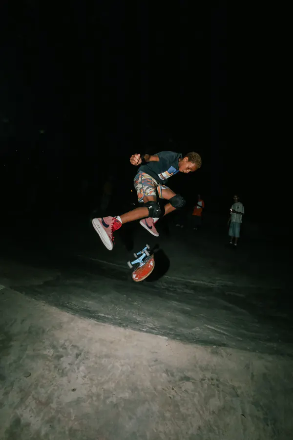 Skater popping a kickflip in the dark